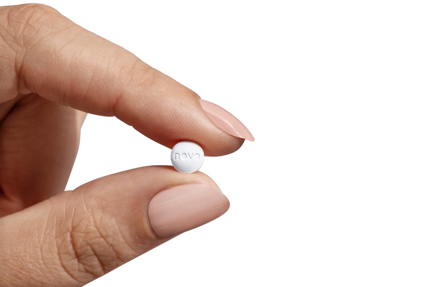 Close-up of a small white weight-loss tablet held between two fingers